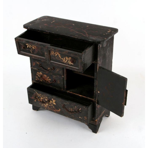 795 - A Japanese lacquer table cabinet with an arrangement of drawers and a cupboard, decorated with gilde... 