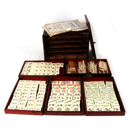 798 - A Chinese bone and bamboo Mah Jong set in a mother of pearl inlaid hardwood case, 24cms wide.