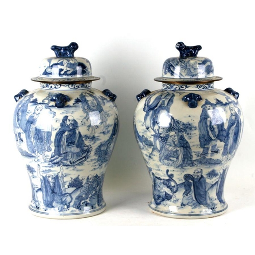 816 - A large pair of Chinese blue & white vases and covers decorated with figures and with fo dog finials... 