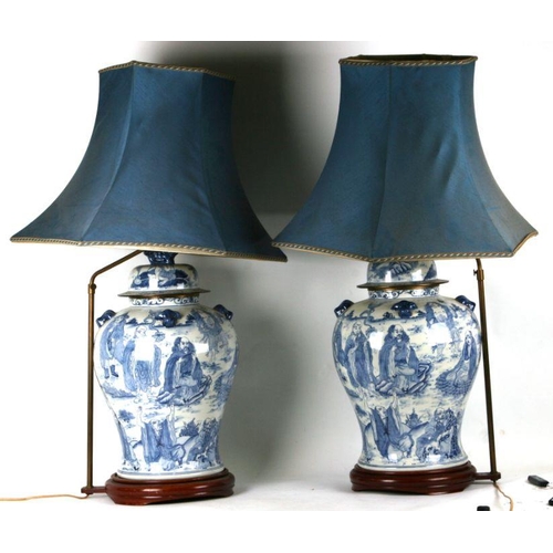 816 - A large pair of Chinese blue & white vases and covers decorated with figures and with fo dog finials... 