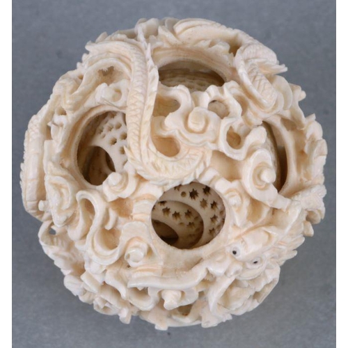 827 - An early 20th century Chinese ivory puzzle ball on stand 17cm high together with two Chinese ivory n... 