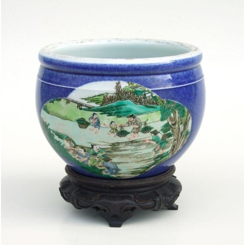 834 - A Chinese fish bowl of small proportions decorated with figures beside a pond, on a blue ground with... 