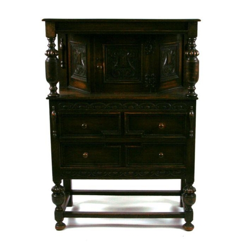 910 - A 17th century style oak court cupboard of small proportions having a cupboard with three carved pan... 