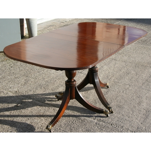 992 - A mahogany twin pedestal dining table on turned columns and tripod base.