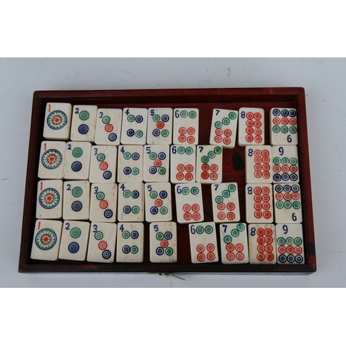 798 - A Chinese bone and bamboo Mah Jong set in a mother of pearl inlaid hardwood case, 24cms wide.