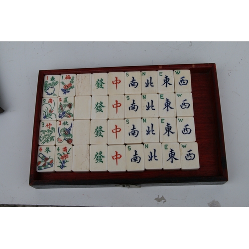 798 - A Chinese bone and bamboo Mah Jong set in a mother of pearl inlaid hardwood case, 24cms wide.