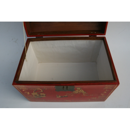 775 - A Chinese red lacquer box and cover decorated with gilt figures within a landscape, 45cms wide.