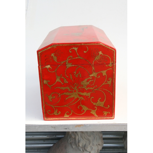 775 - A Chinese red lacquer box and cover decorated with gilt figures within a landscape, 45cms wide.