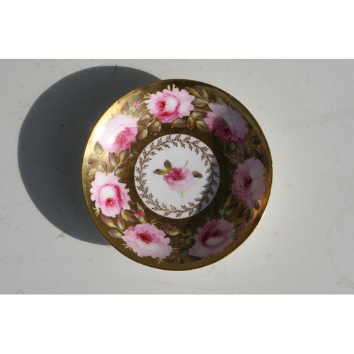 134 - An early 19th century Coalport cup and saucer, finely painted with a large band of pink roses and bu... 