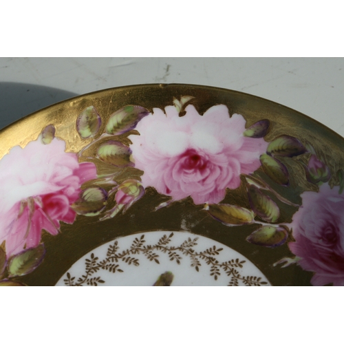 134 - An early 19th century Coalport cup and saucer, finely painted with a large band of pink roses and bu... 