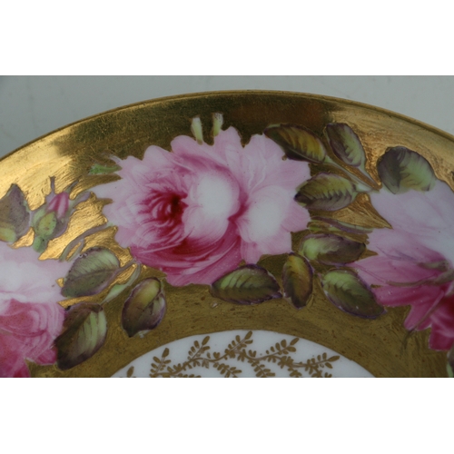 134 - An early 19th century Coalport cup and saucer, finely painted with a large band of pink roses and bu... 