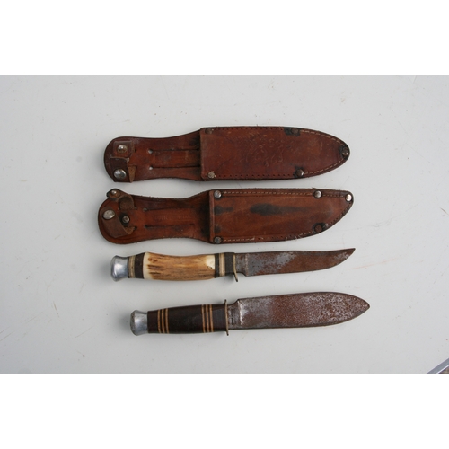 38 - Two German sheath knives in leather scabbards, 21cms long; together with a carved wooden box contain... 