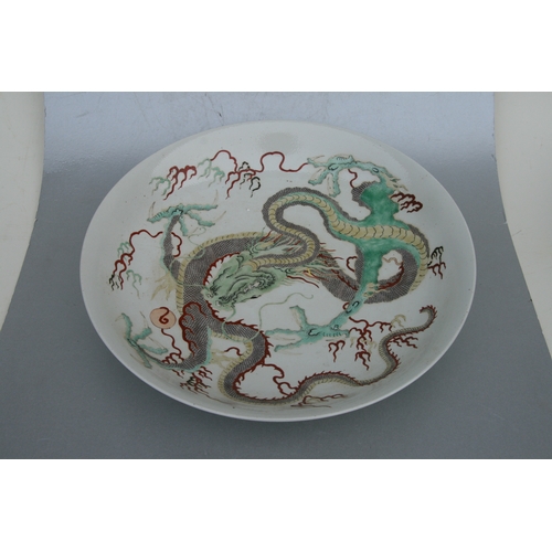 846 - A Chinese famille vert charger decorated with a scrolling dragon, 42cms diameter; together with a Ch... 