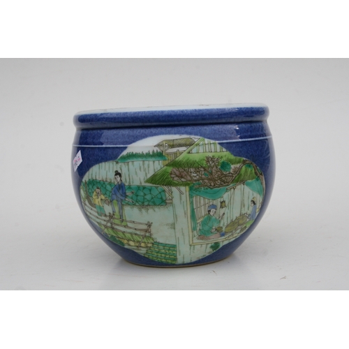 834 - A Chinese fish bowl of small proportions decorated with figures beside a pond, on a blue ground with... 