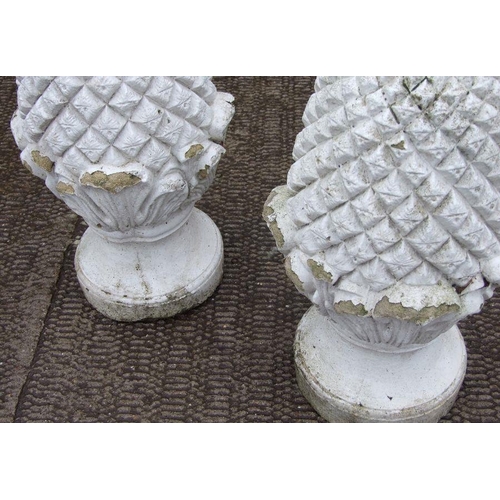 10 - A pair of well weathered painted reconstituted stone pineapple finials, 60cms high (2).