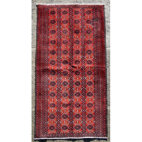 109 - A Persian hand knotted woollen rug, on a red ground, 195 by 100cms (18/126).