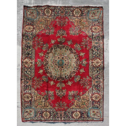 113 - A Persian Tabriz woollen hand made rug with with central foliate gul within floral borders, on a red... 