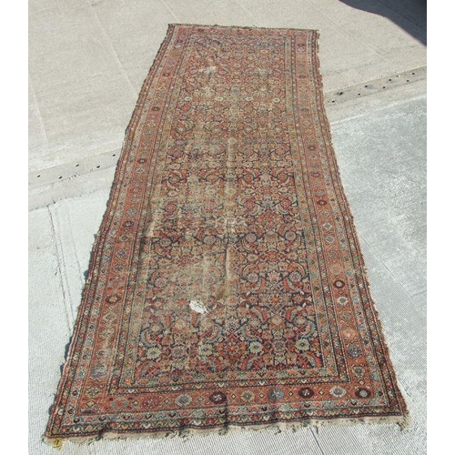 114 - A Persian Kellah runner with repeating geometric pattern on a red ground, 472 by 174cms.