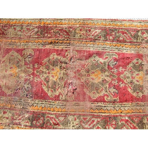 115 - A Turkish runner with repeated floral decoration on a red ground, 392 by 73cms.