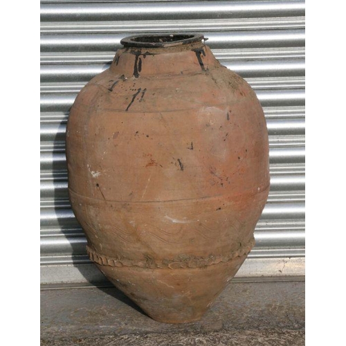 18 - A large terracotta olive jar with banded and crimped decoration, approx 68cms high.