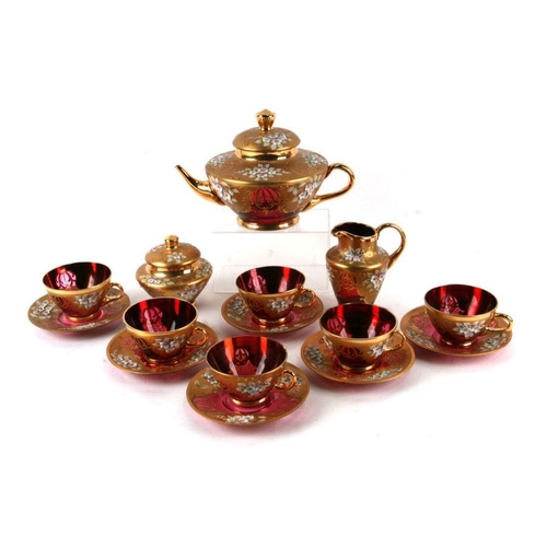 230 - A Bohemian Czech glass tea set in ruby glass with orate gilt and relief foliate decoration comprisin... 