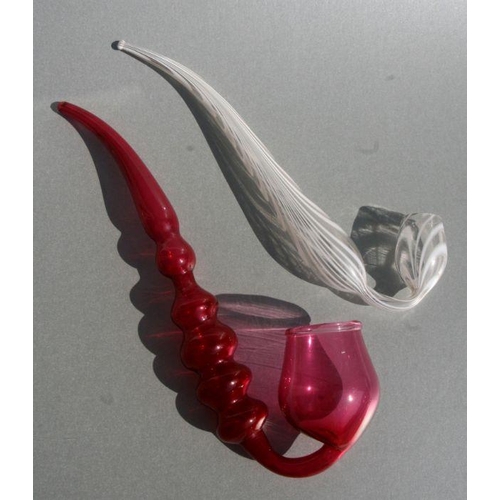 234 - A Nailsea style glass pipe, 34cms long; together with a similar cranberry glass pipe, 37cms long (2)... 