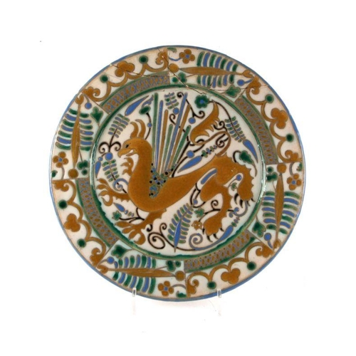 275 - A continental Arts & Crafts style charger decorated with a stylised dragon within a foliate bord... 