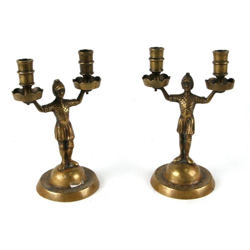 334 - A pair of brass figural twin-arm candlesticks.