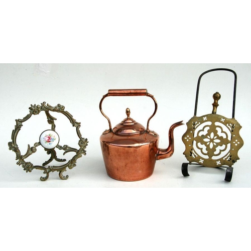 341 - A Victorian copper kettle, 28cms high; together with two brass trivets (3).