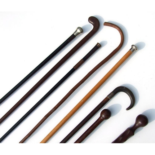 350 - Eight vintage walking sticks including a silver topped example and ethnic clubs