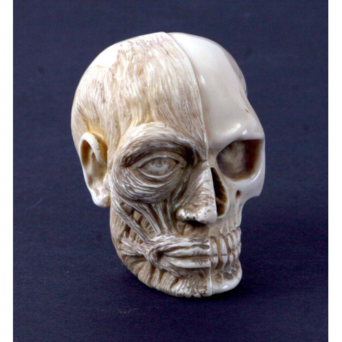 369 - A 19th century carved ivory memento mori study of a skull, one half of the face exposing flesh and s... 