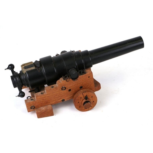 37 - A cast iron miniature cannon on a wooden carriage, 28cms long.