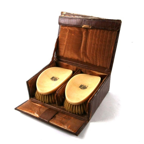 375 - An Edwardian cased pair of ivory backed brushes.