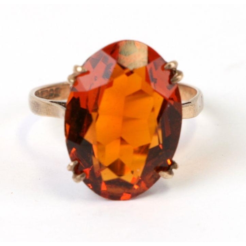 500 - A 9ct gold dress ring set with a large oval amber stone, approx UK size 'Q', 4g.