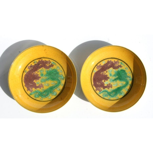 523 - A pair of Chinese shallow bowls, each decorated with dragons chasing a flaming pearl amongst clouds ... 