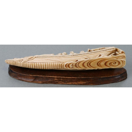 536 - A Japanese carved ivory boat with a crew of pirates, 1signed to the underside9cms long, on a wooden ... 