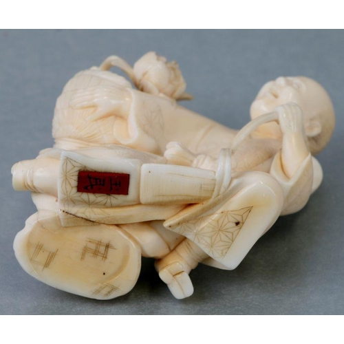 537 - A Japanese carved ivory figure of a fruit seller, 6cms wide; together with a Japanese carved ivory n... 