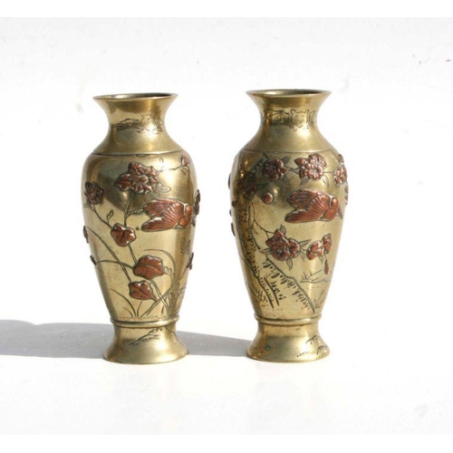 558 - A pair of Japanese Meiji period mixed metal baluster vases, each decorated in relief with storks wit... 