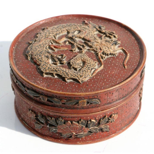 560 - A Chinese cinnabar lacquer circular box and cover decorated with a dragon and prunus, 11cms diameter... 