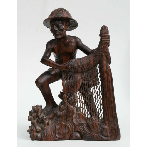 564 - A large Asian hardwood carving depicting a fisherman with his net, 35cms high.