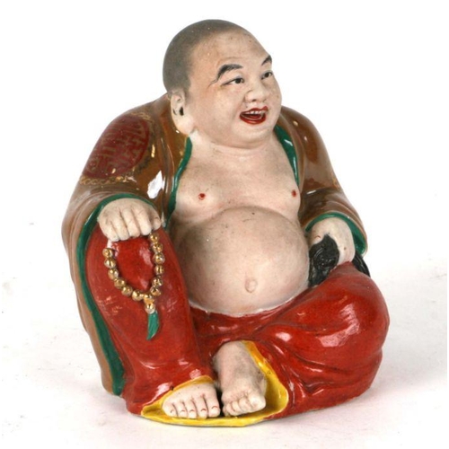 574 - A Chinese figure of a fat Buddha with glazed robes and bisque body, twin impressed seal marks to the... 