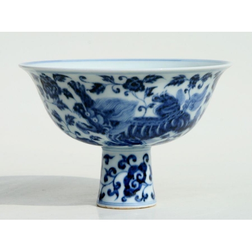 584 - A Chinese blue & white stem cup decorated with shishi amongst scrolling foliage, with six charac... 