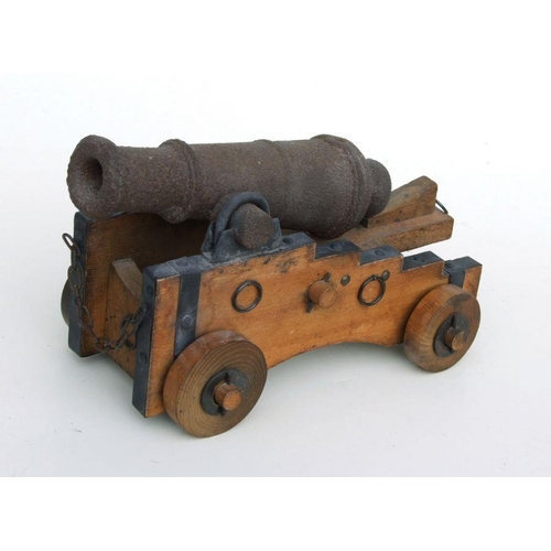 59 - A cast iron signal cannon, possibly 18th century, on a later wooden carriage, 32cms long.