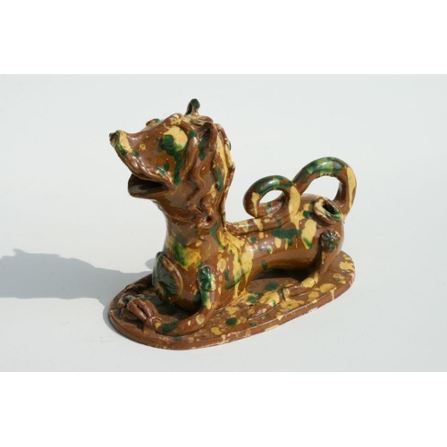 602 - A Turkish Canakkale pottery figure in the form of a stylised recumbent lion, 18cms wide.