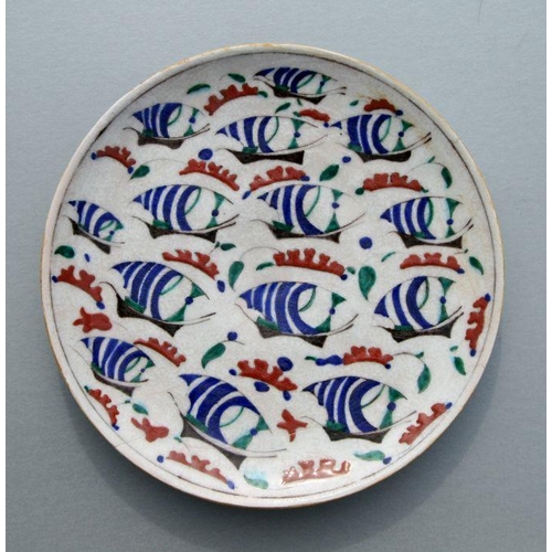 604 - A Turkish / Iznik plate decorated with stylised sailing ships, 30cms diameter.