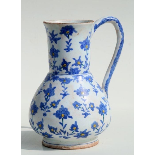 606 - A Turkish / Iznik water jug decorated with flowers, 23cms high.