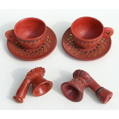 608 - A pair of Turkish Tophane coffee cups and saucers; together with two Turkish pipe bowls.