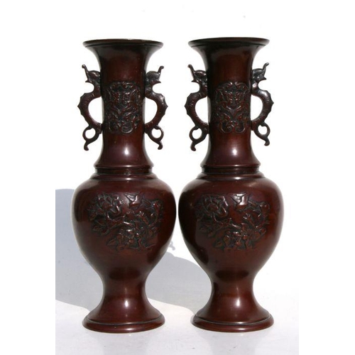 615 - A pair of Japanese Meiji period bronze baluster vases with applied mythical animal handles and prunu... 