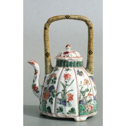 618 - A Chinese famille rose teapot decorated with flowers and insects, 17cms high.