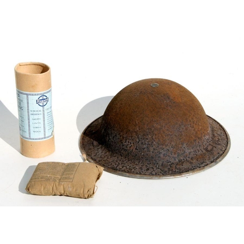 62 - A WWII steel helmet together with a field dressing and other items..